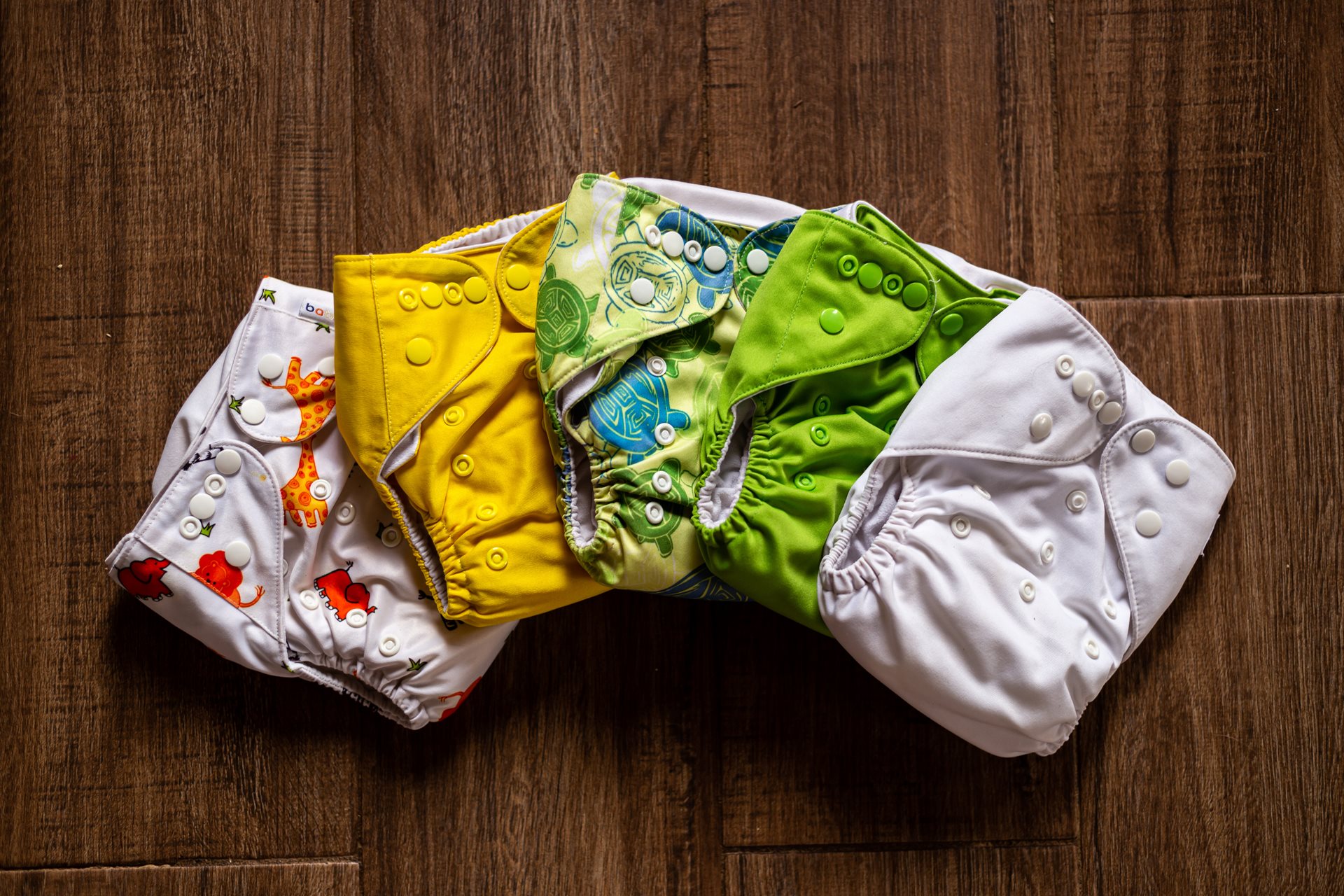 Array of colourful cloth nappies on a table