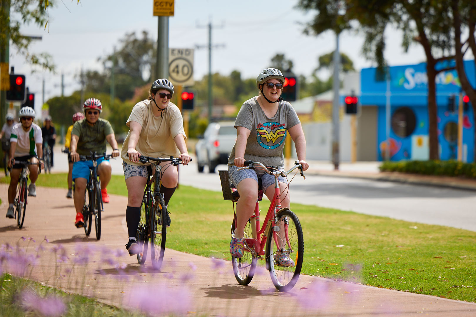 People riding down a suburban street.