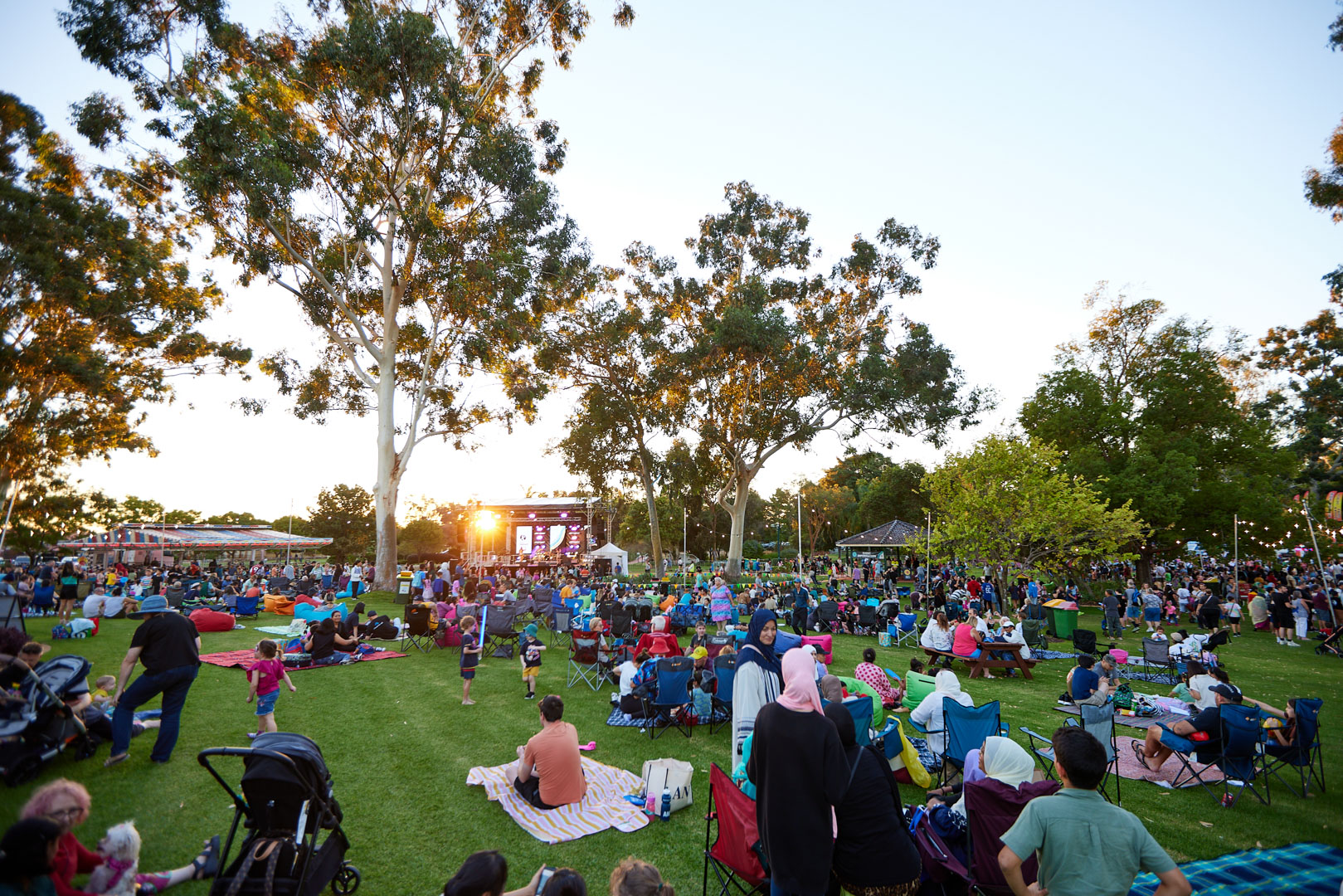 Event attendees sitting on grass in a park