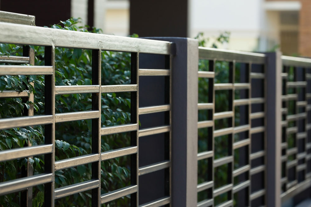 Front fence in front of a hedge.