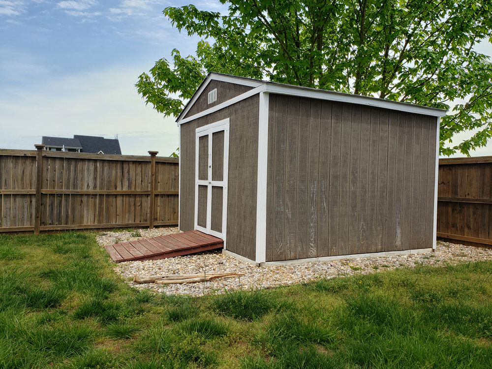 Brown shed in a residential backyard.