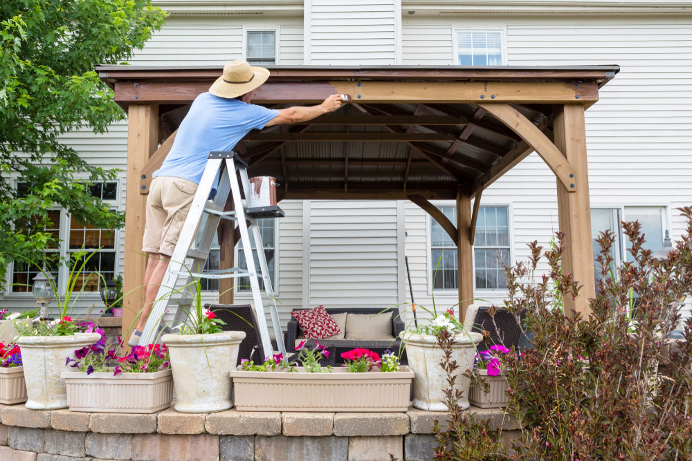 Man painting a pergola.