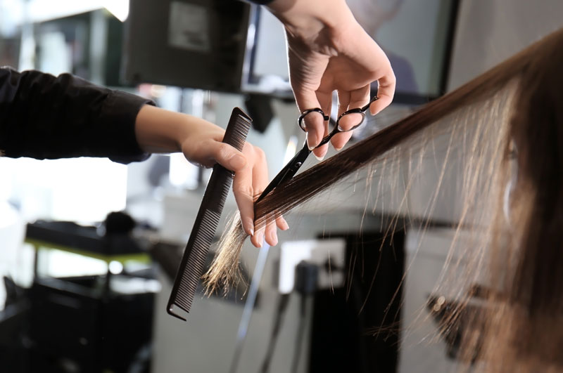 Hairdresser cutting a woman's hair with scissors