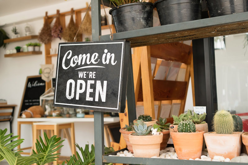 Shop Open sign hanging on a shelf