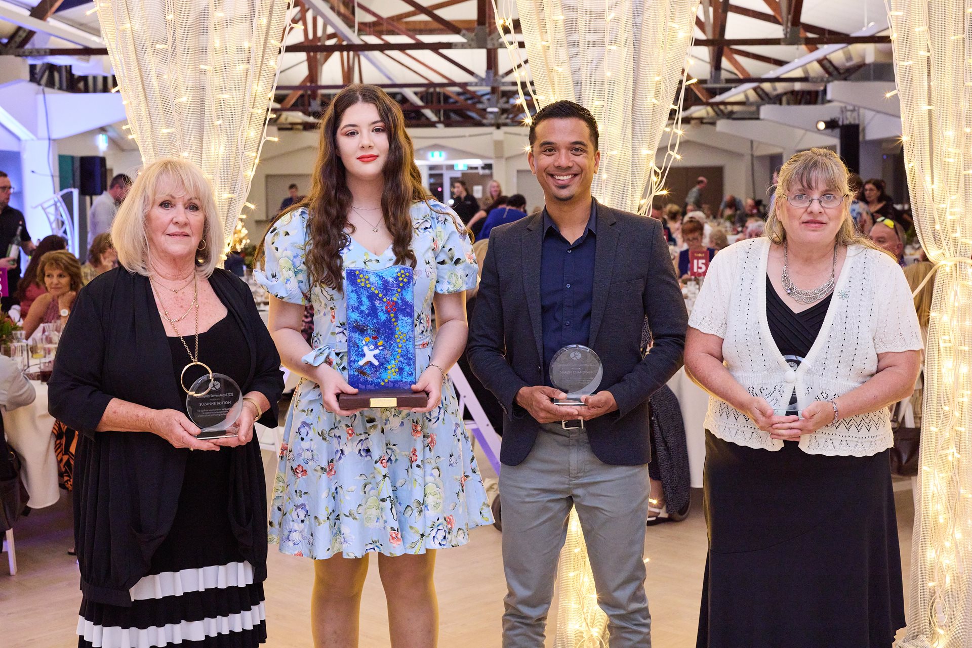 2022 Community Service Award winners holding their awards at the Civic Dinner in the Glasshouse