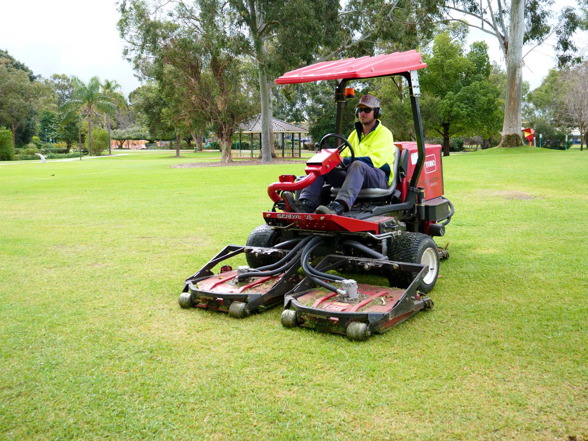 Man driving lawnmower in Faulkner Park.