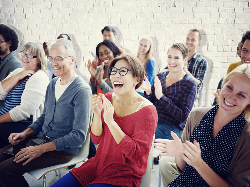 Adults clapping and laughing at event