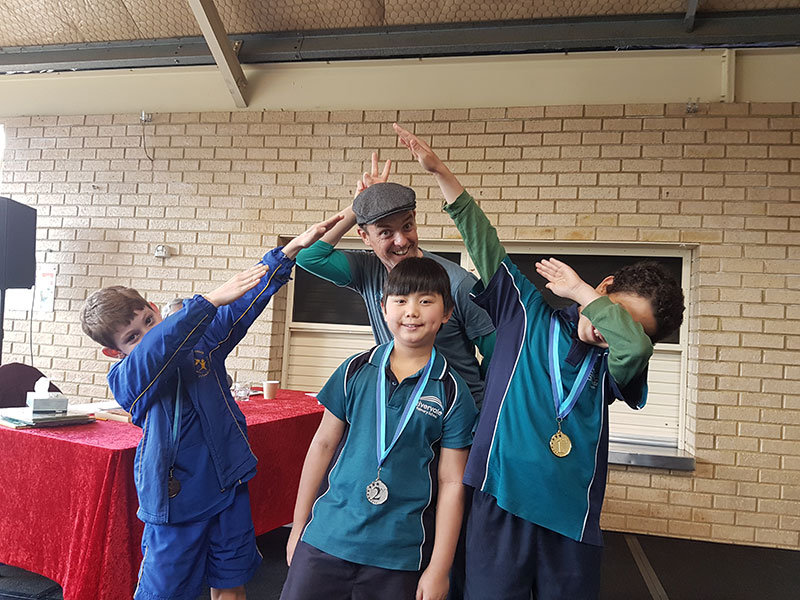 Children wearing medals and an author dabbing at the 2108 Read Out Loud Awards 