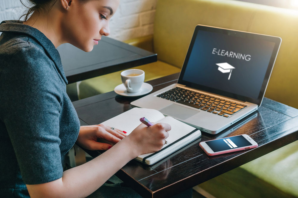 Man and woman using laptop to study.