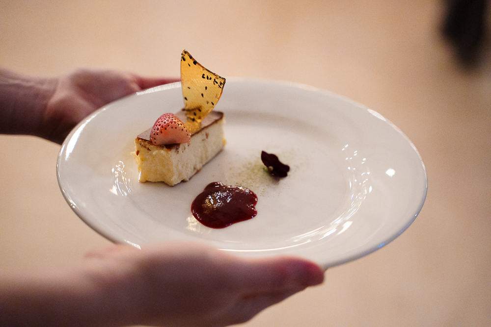 Hands holding a plate of dessert