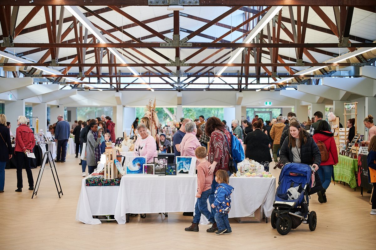 Market stalls in The Glasshouse with a crowd of people