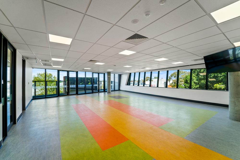 Creche space featuring coloured flooring and large windows.