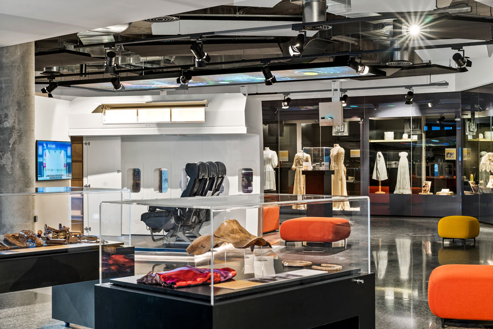 Museum displays including racing memorabilia, airplane exhibit and conserved dresses.