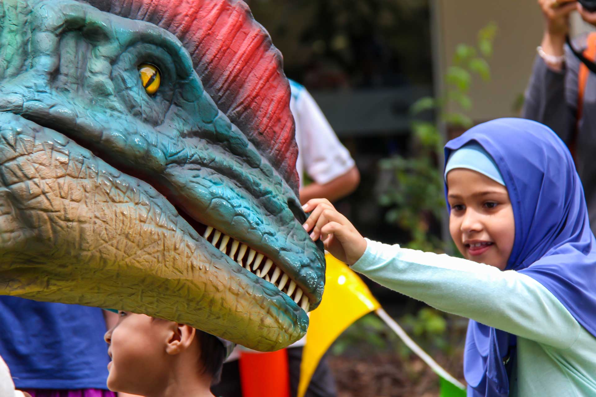 Child patting a dinosaur