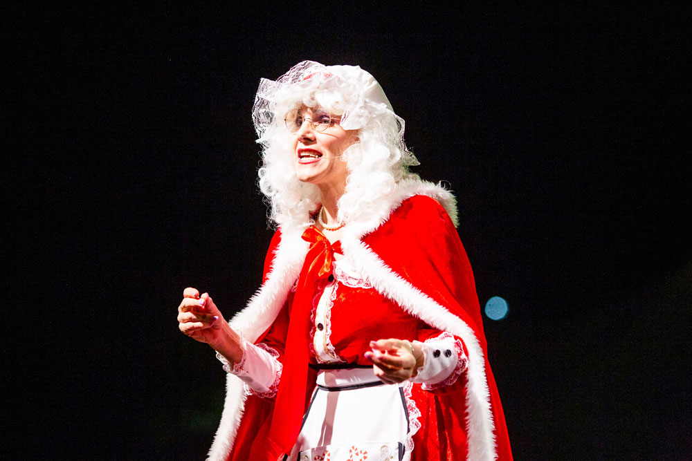 Mrs Claus singing on stage at Carols in the Park