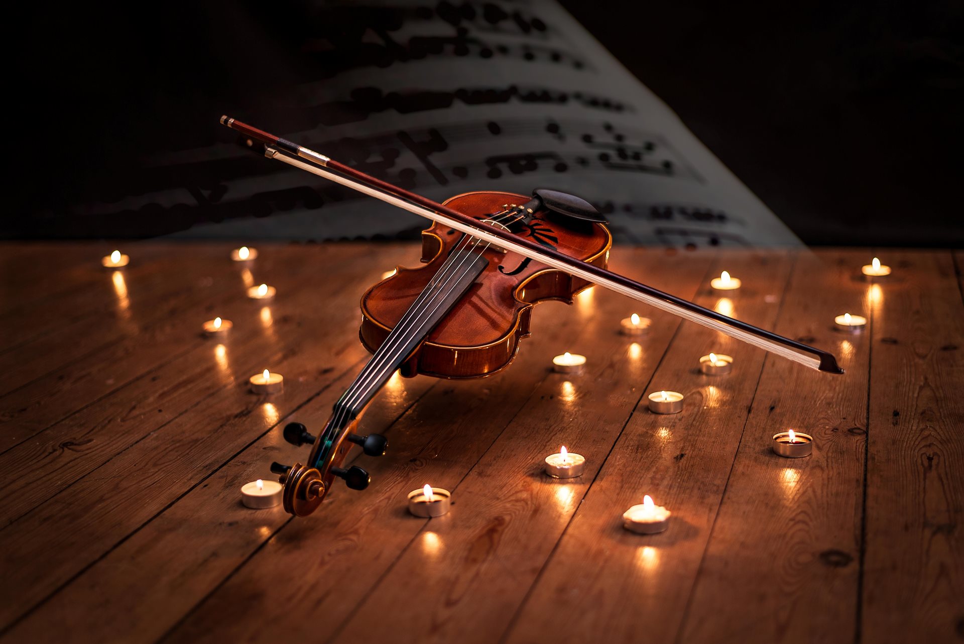 Violin surrounded by tea lights