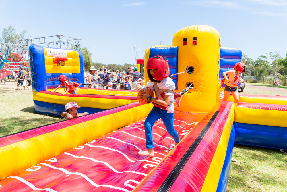 Child at KidzFest running on inflatable amusement