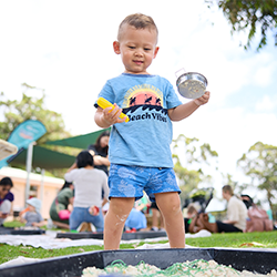 Child smiling in a sandpit