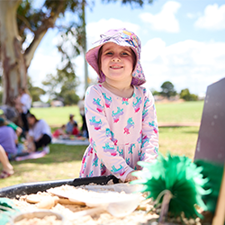 Child smiling in a sandpit