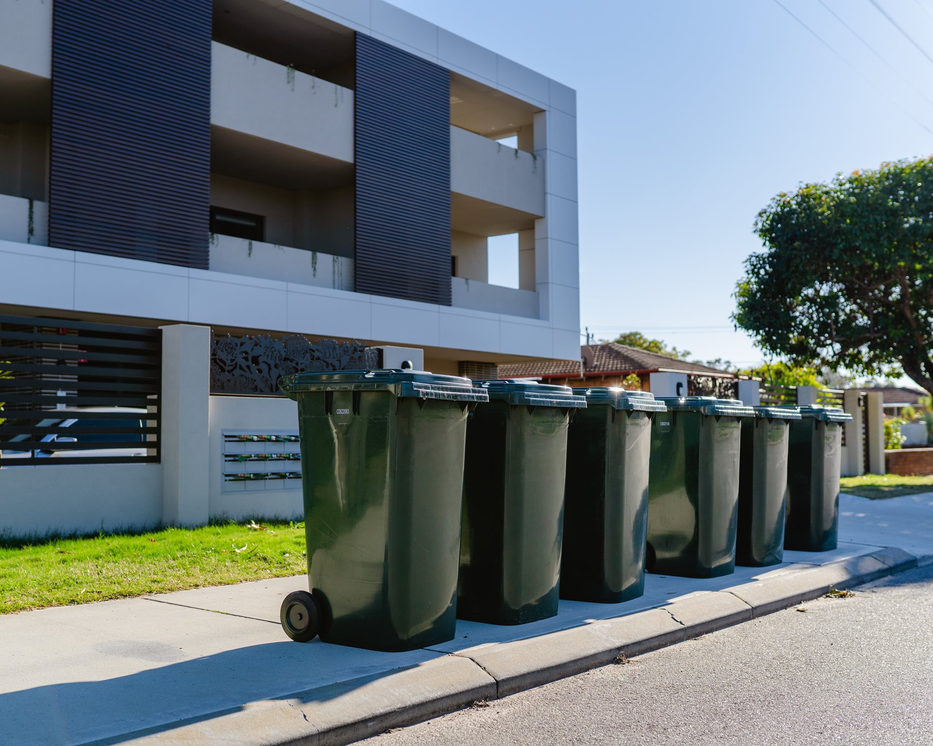 Green waste bins outside apartment block