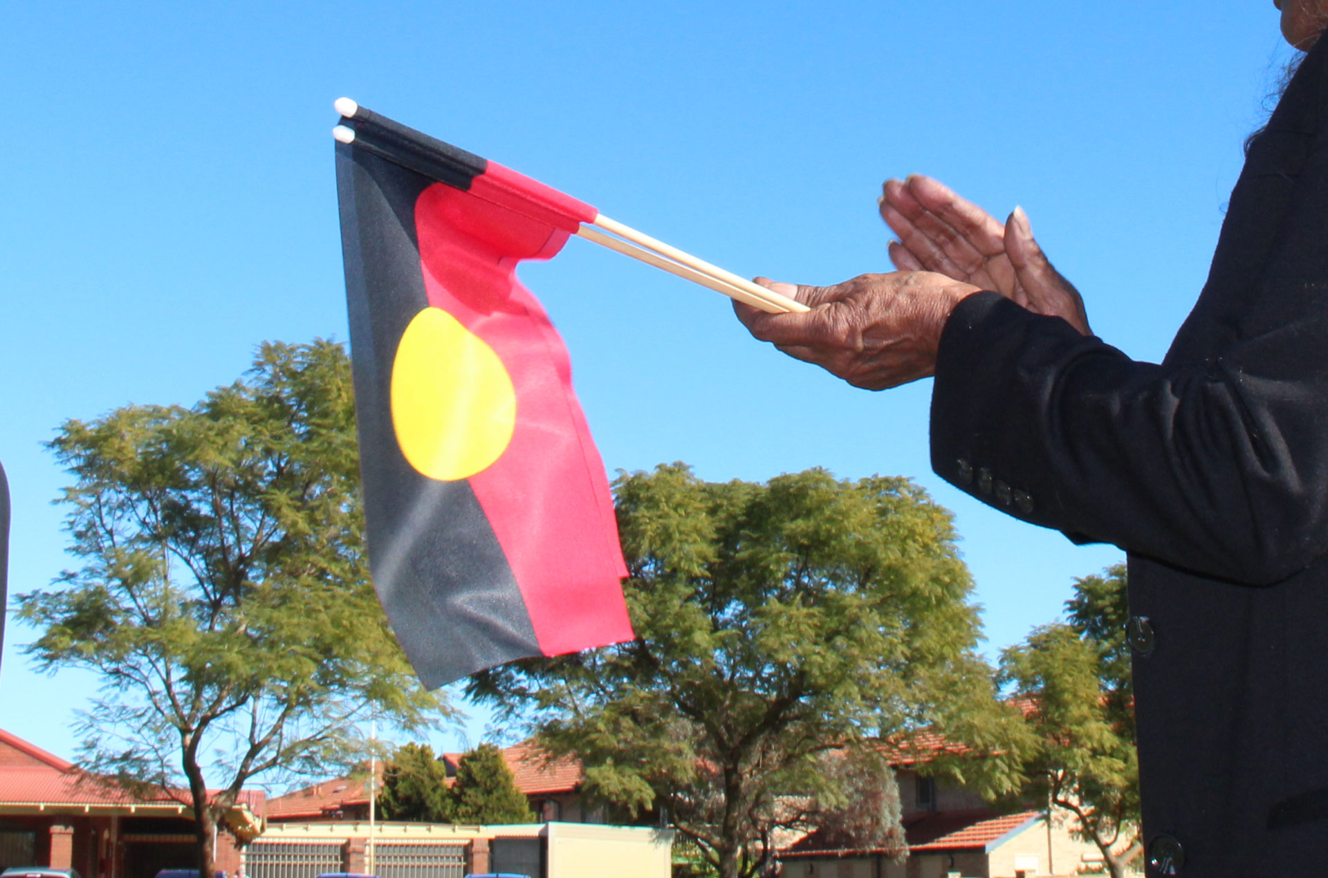 Aboriginal flag held in a woman's hands.
