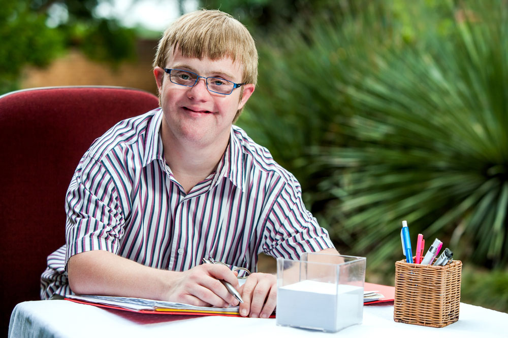 Smiling man with Down Syndrome.
