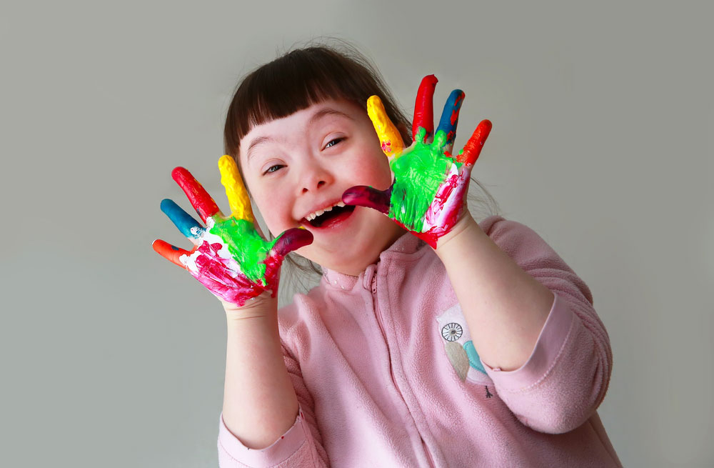 Smiling child with painted hands.