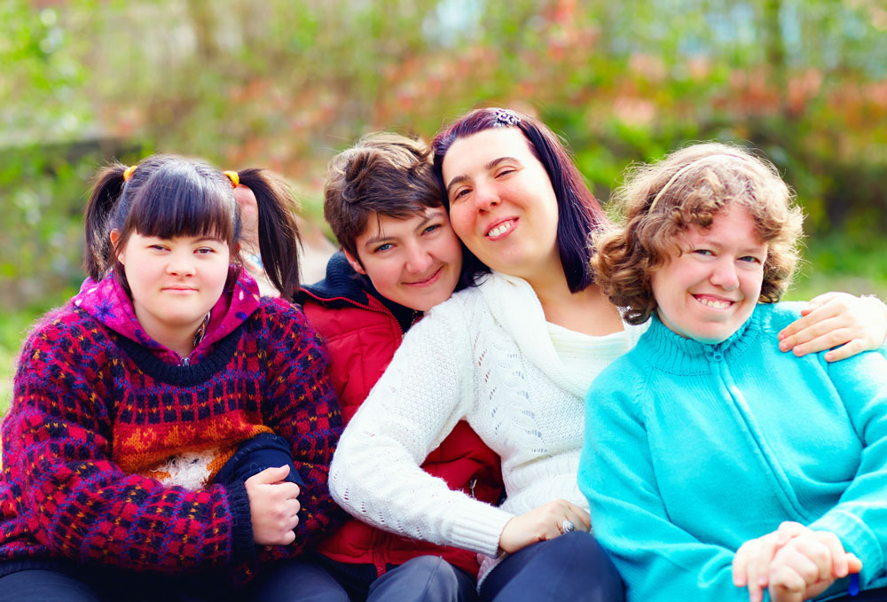 Group of women living with disability smiling in a group.