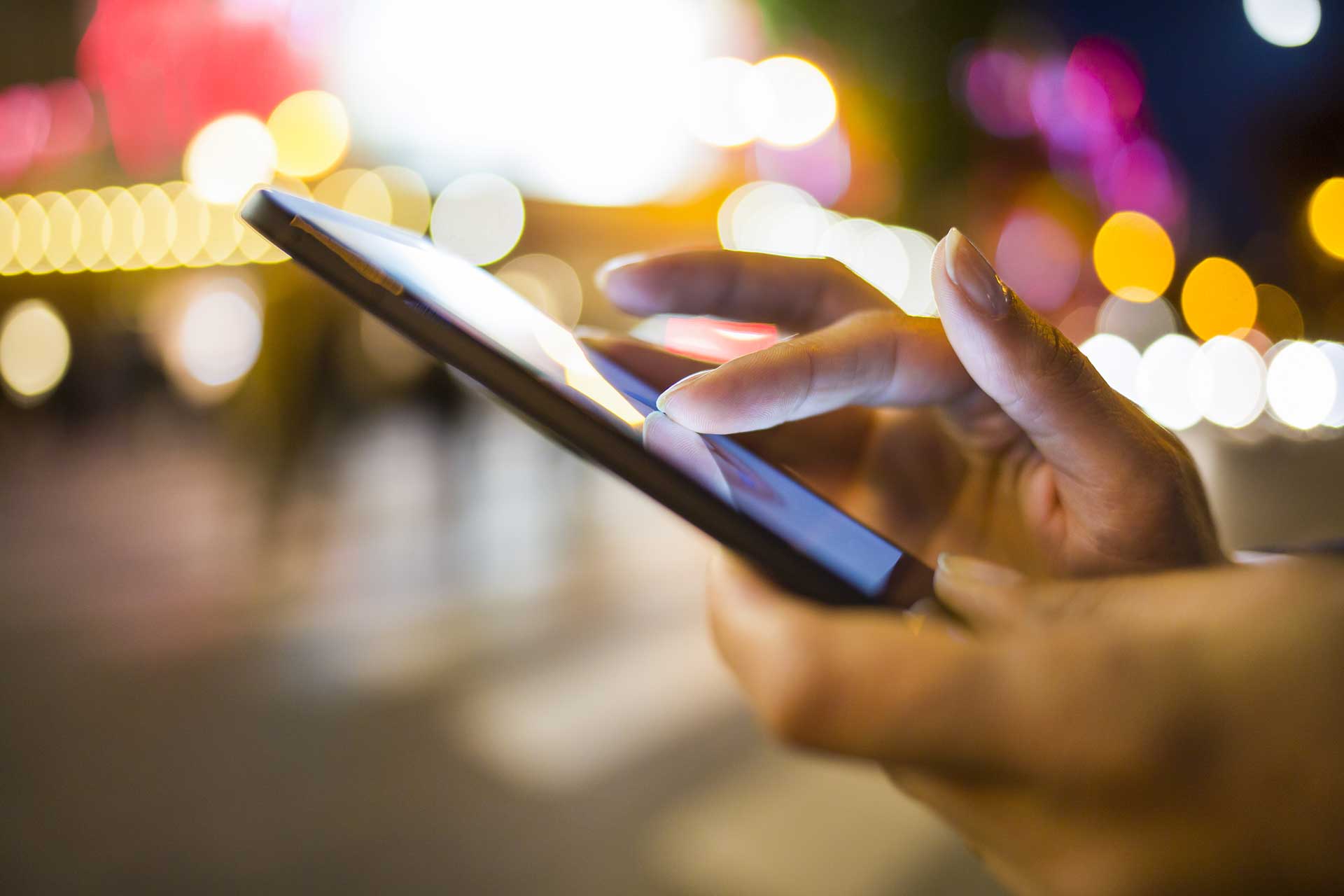 A person holding a phone at night.