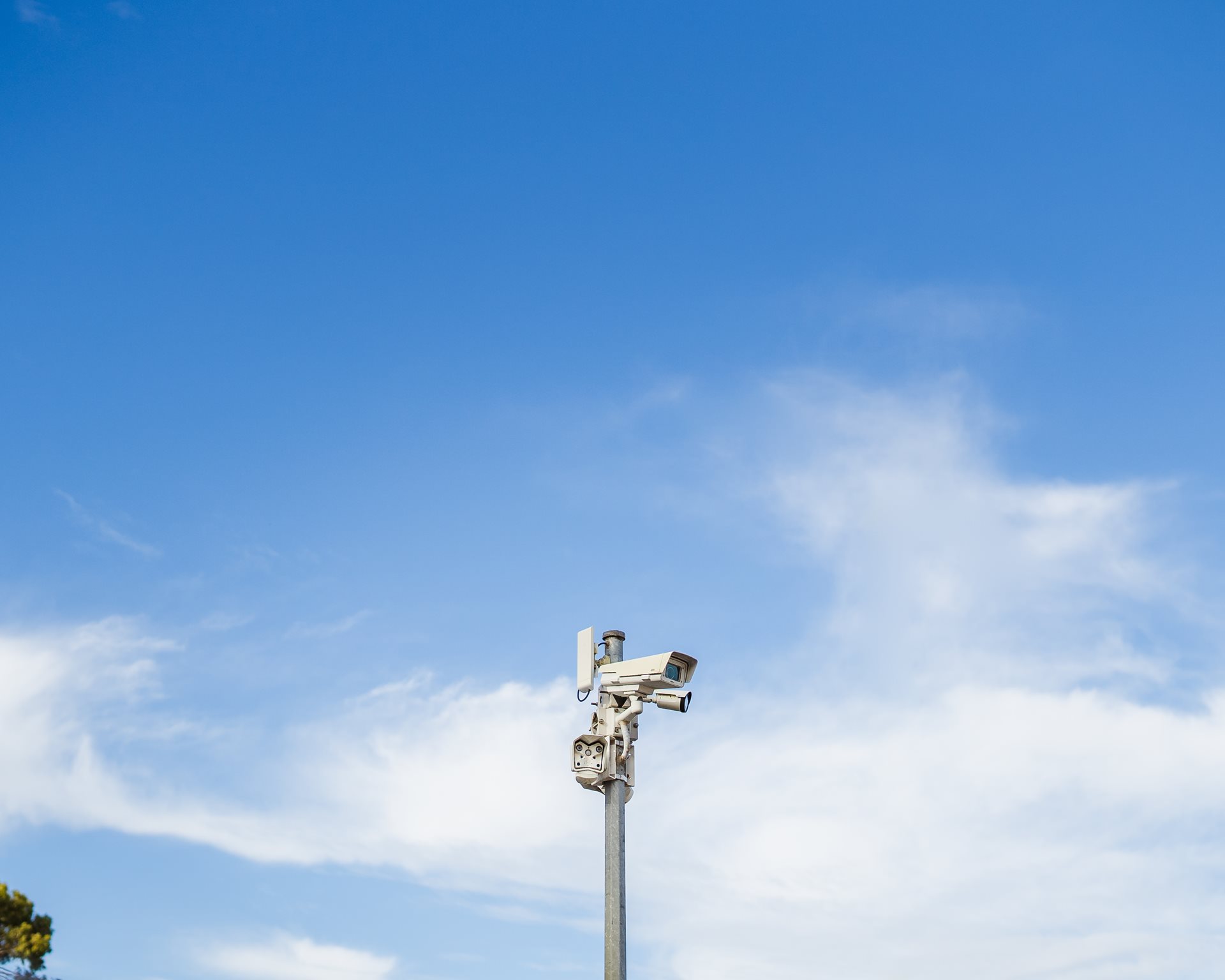 CCTV cameras against a slightly cloudy blue sky