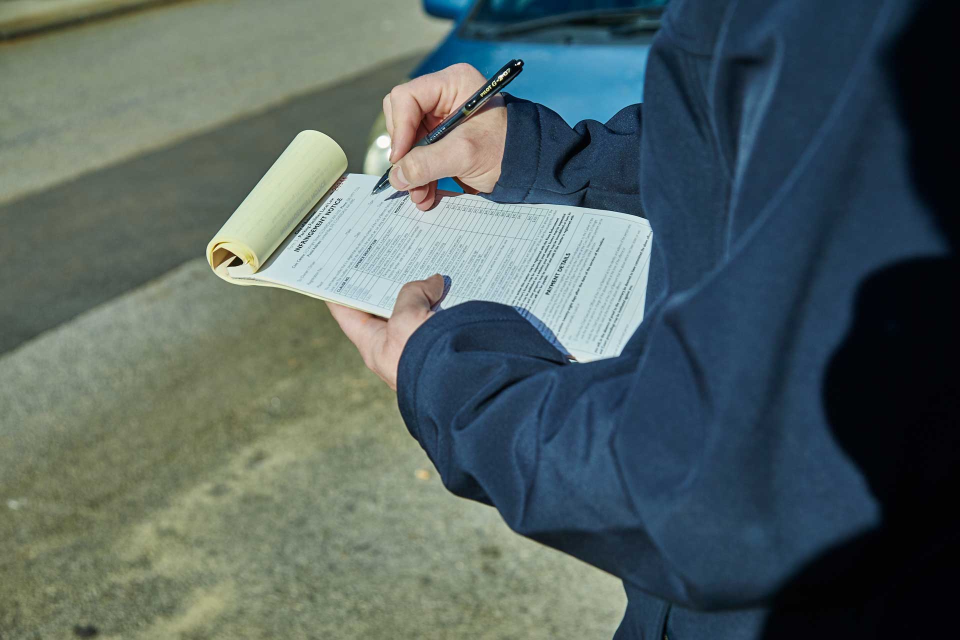 A ranger writing out an infringement notice.