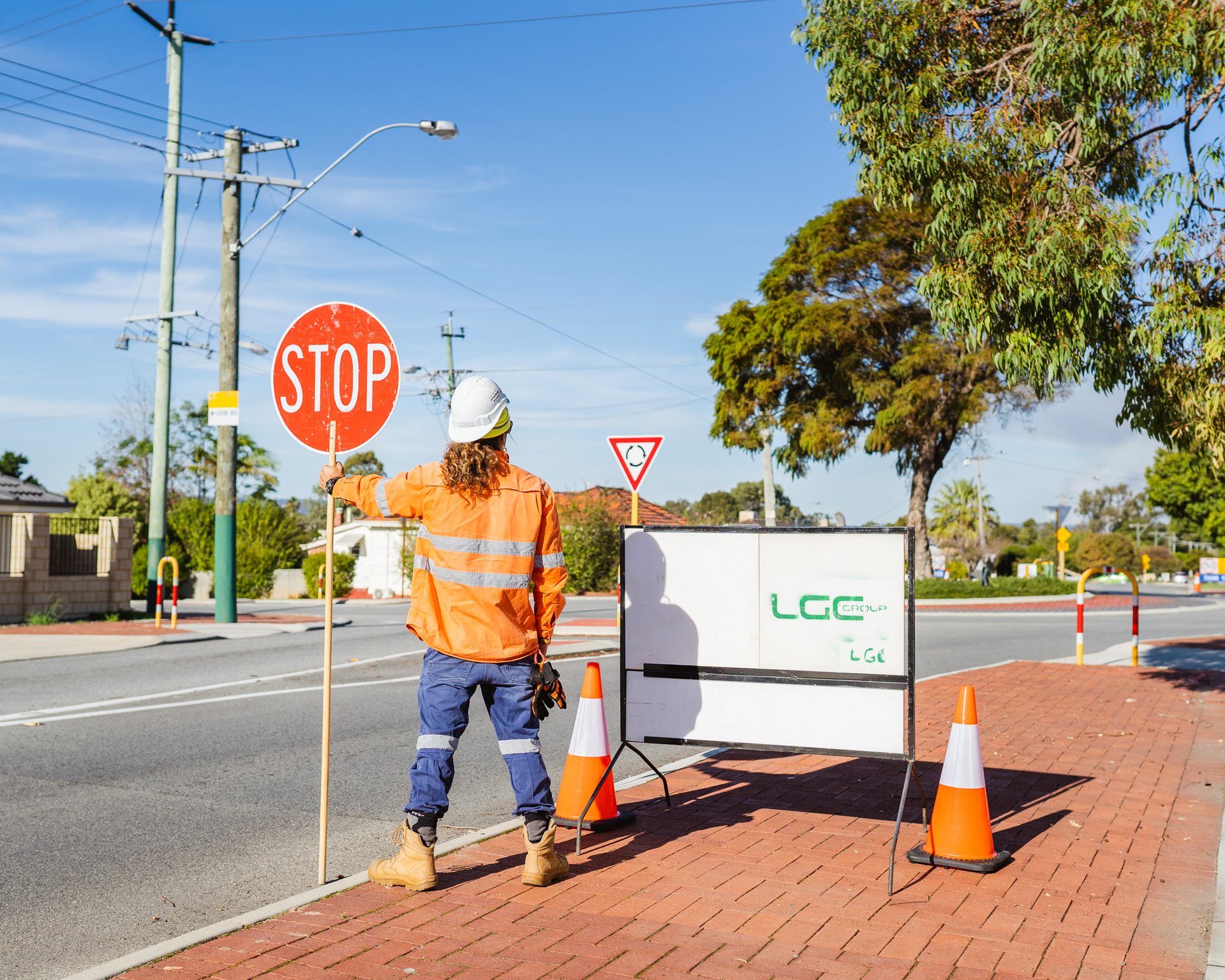 Contractor holding stop sign for street roadworks.