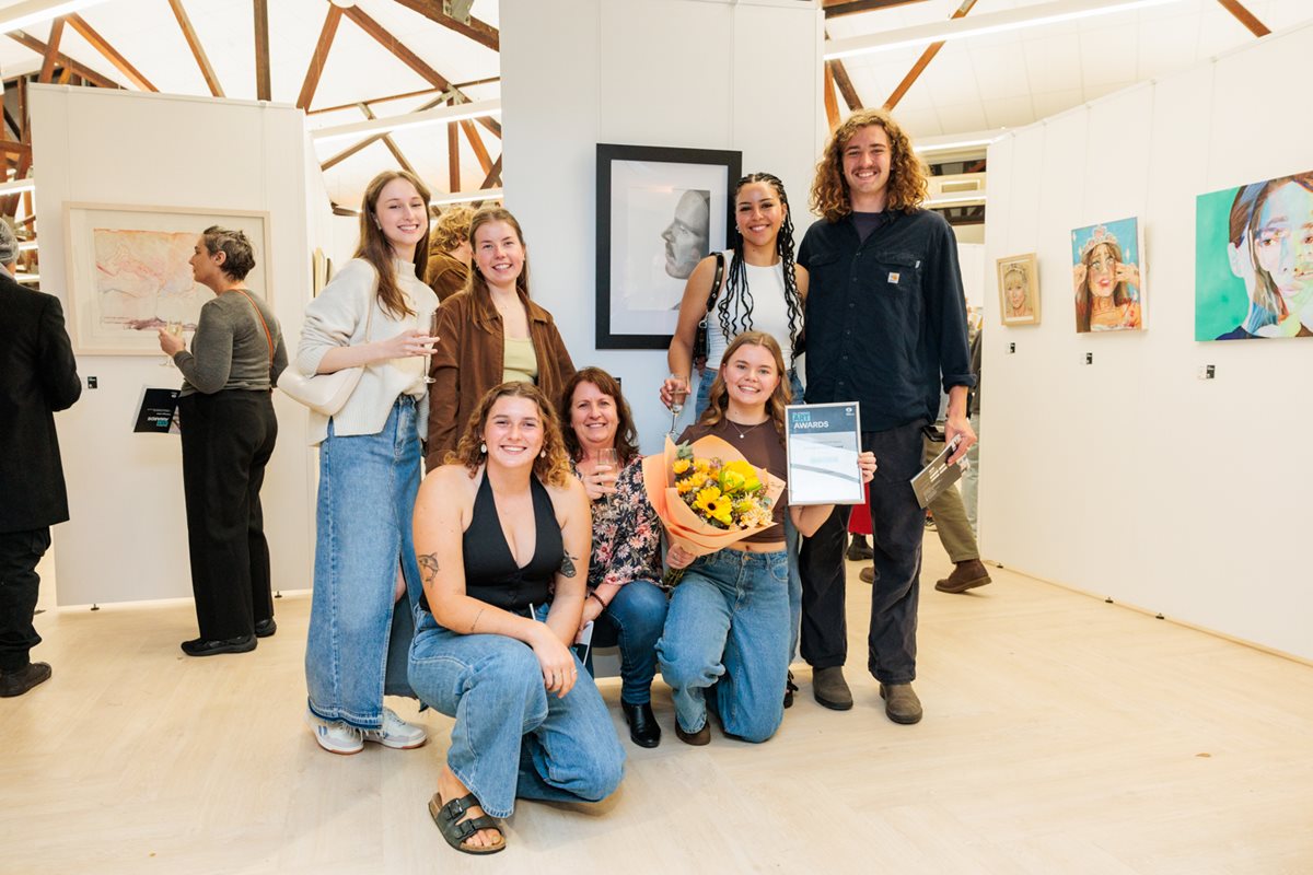 2024 City of Belmont Art Awards winner in front of their work with a group of friends